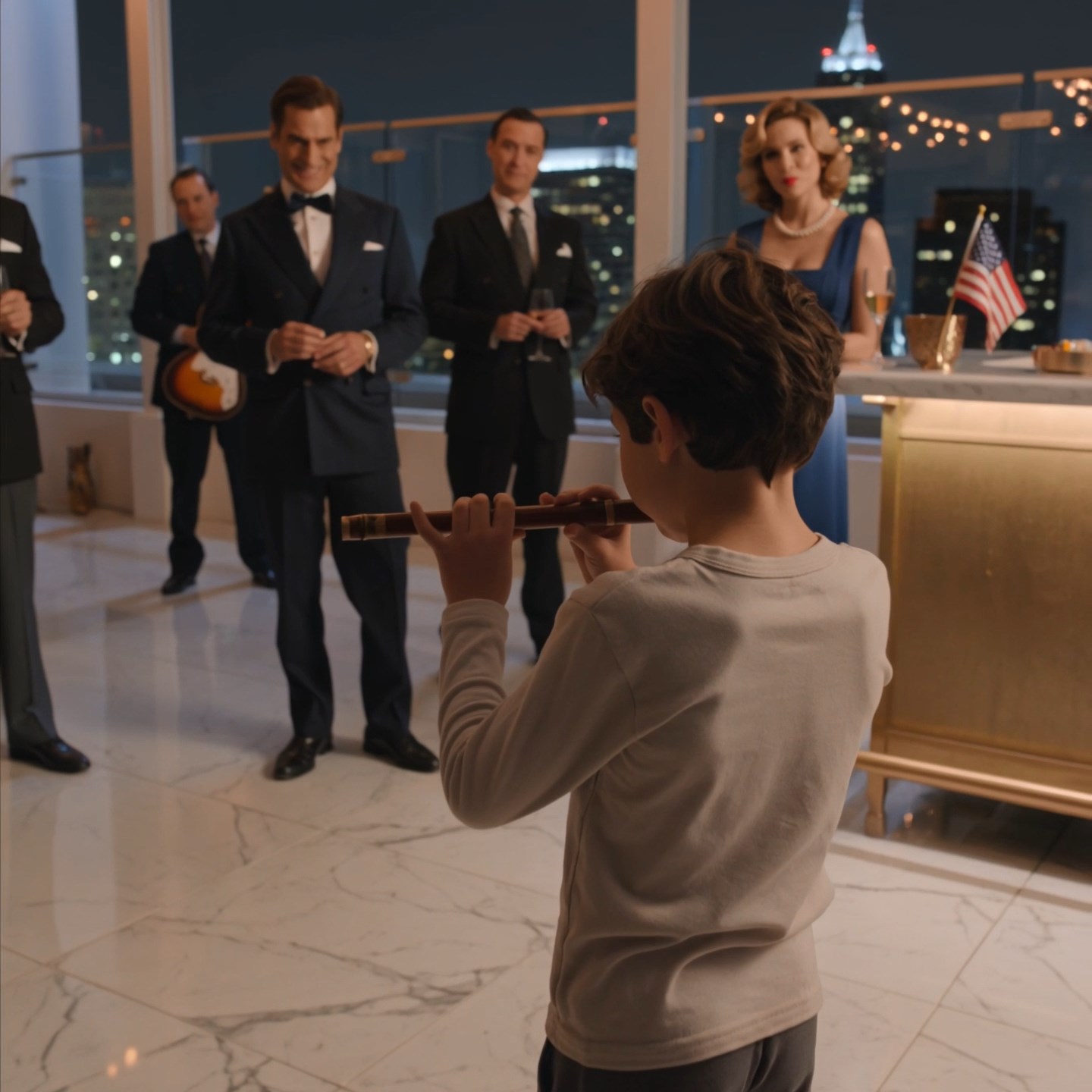 A barefoot eight-year-old walked into a millionaire rooftop gala holding an old wooden flute. A rich guest laughed and told him to ‘impress the room’—but when the boy played the song his mother taught him, the band went silent, champagne glasses froze in midair, and the hostess turned pale after noticing the tiny mark hidden on his flute…